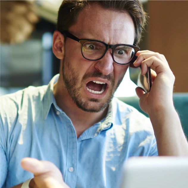 Tense man on the phone at a laptop