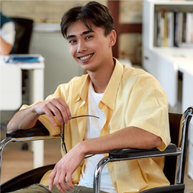 Smiling young man in a wheelchair, in a yellow shirt